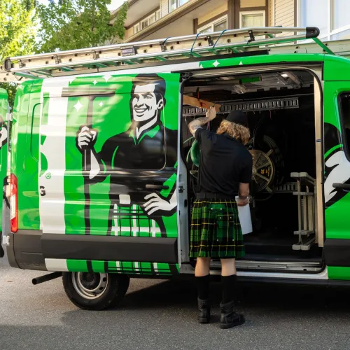 a person standing next to a green van