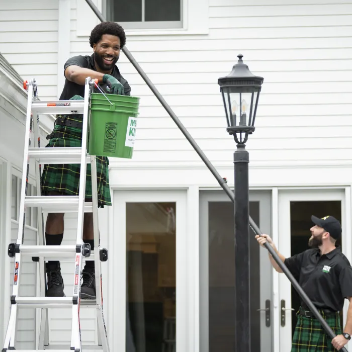 Two men cleaning gutters