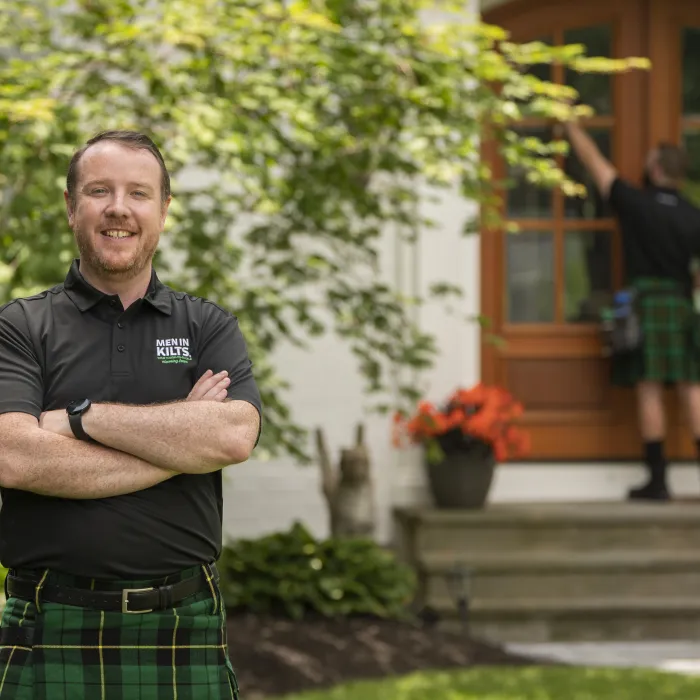 A man in front of a house with his arms crossed